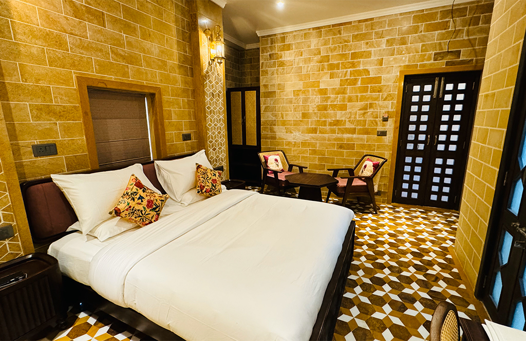 Elegant guest room with golden sandstone details at Guulab Haveli